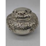 An American silver tea caddy, embossed decoration, stamps to base, 175g, H.8cm W.10cm