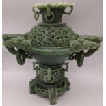A Chinese spinach jade incense burner, handles in the form of dragon heads, pierced lid, raised on