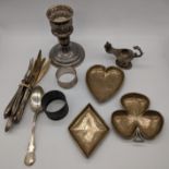 A collection of silver items to include a Reed & Barton candlestick, diamond heart and clubs dishes,