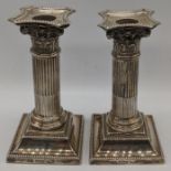 A pair of Walker & Hall Edwardian silver candlesticks of corinthian column form, hallmarked