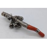 A Continental silver babies rattle with whistle, coral handle, L.17.5cm