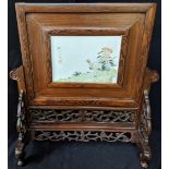 An 18th century Chinese porcelain screen depicting a chicken mounted on a hardwood stand