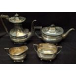 An early 20th century silver tea set, each piece raised on four ball feet, hallmarked Sheffield,