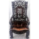 A late 19th century Chinese hardwood armchair, profusely carved with dragons, bats and foliate