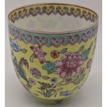 A Chinese Imperial yellow ground eggshell tea cup decorated with stylised dragons and flowers,