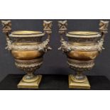 A pair of 19th century bronze urns, flanked by boar heads, the handle terminals in the form of a