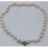 A pearl and diamond choker, single string of freshwater pearls, the clasp mounted with a central