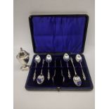 A set of silver apostle spoon with a silver pepper