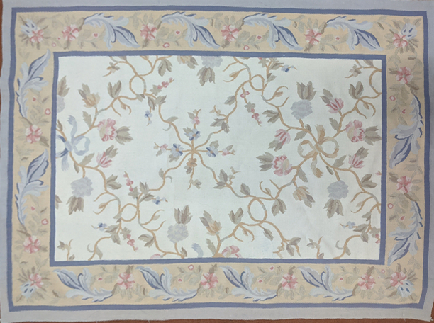 An Aubusson style embroidered rug with floral designs, blue borders, 187cm x 119cm