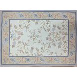 An Aubusson style embroidered rug with floral designs, blue borders, 187cm x 119cm