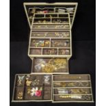 A set of drawers containing a collection of costume jewellery to include brooches, earrings, rings