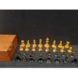 An early 20th century Staunton chess set, a red crown to the top of the black knight and castle