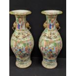 A pair of Chinese 19th century famille rose vases depicting figural scenes and decorated with