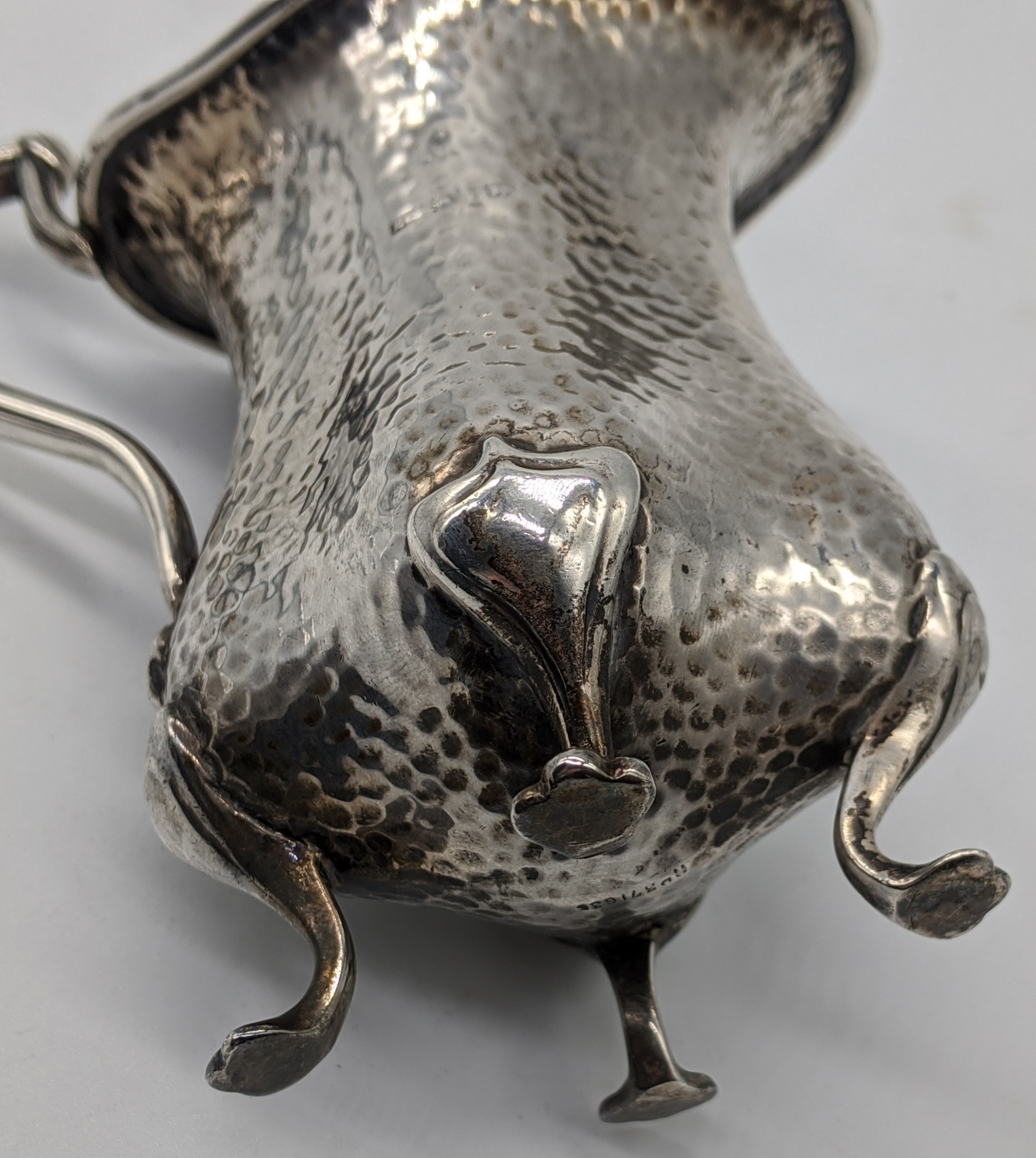 An early 20th century Arts and Crafts silver jug, planished finish, raised on four paw feet, - Image 2 of 4