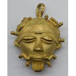 An 18ct gold African mask pendant/brooch, marks for 18ct and tested as 18ct, 35g, L.4cm