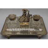 A late Victorian silver desk inkwell, central raised chamberstick with flanking cut glass silver