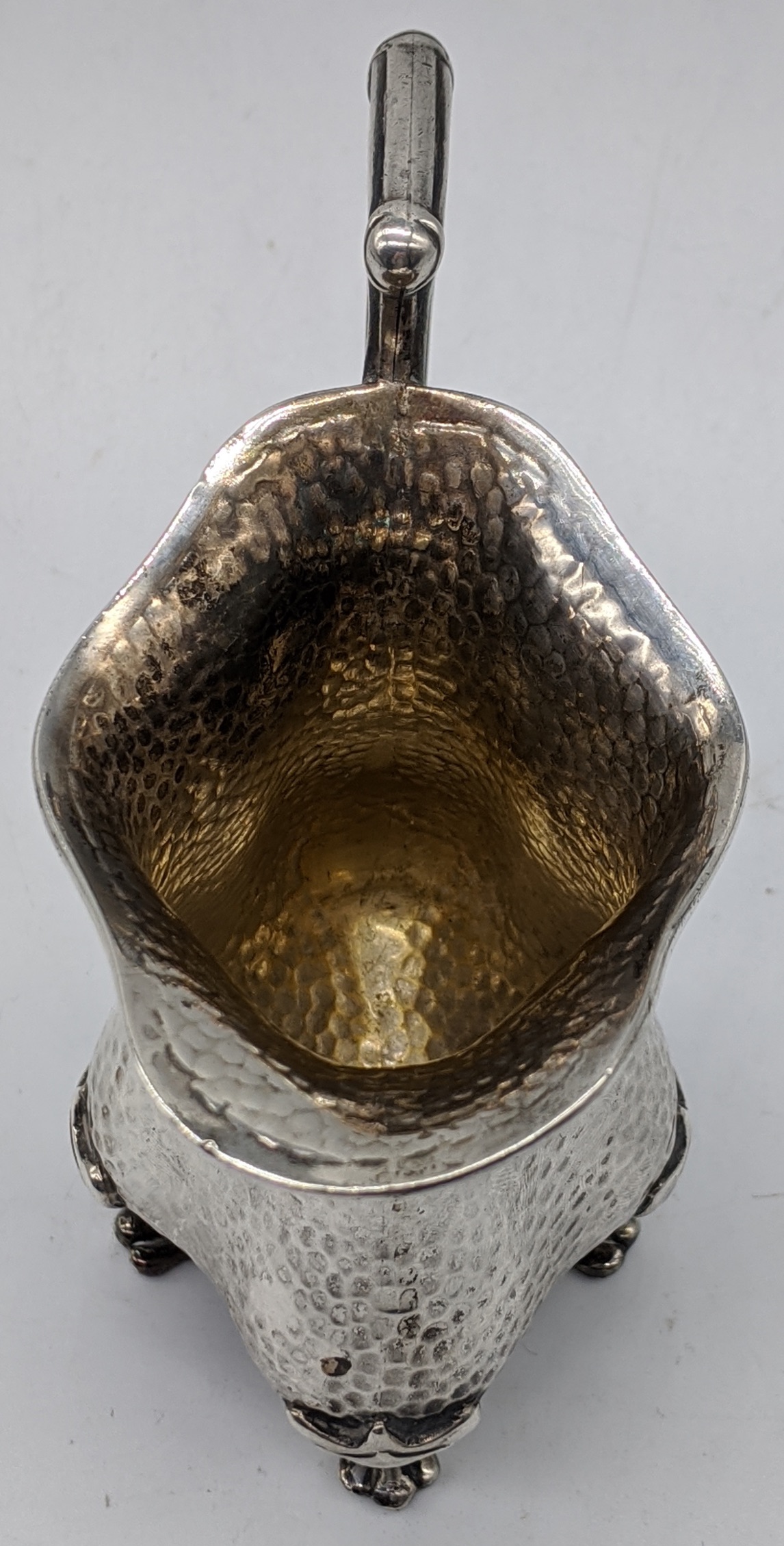 An early 20th century Arts and Crafts silver jug, planished finish, raised on four paw feet, - Image 4 of 4
