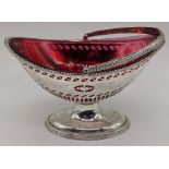 A George III silver sugar basket, pierced and etched body, vacant cartouche, swing handle, red glass