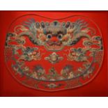 An early 20th century Chinese embroidery of a dragon, mounted on a red mount and wooden frame, H.