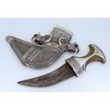 A silver Omani Jambiya dagger having horn hilt, ornate chased decoration