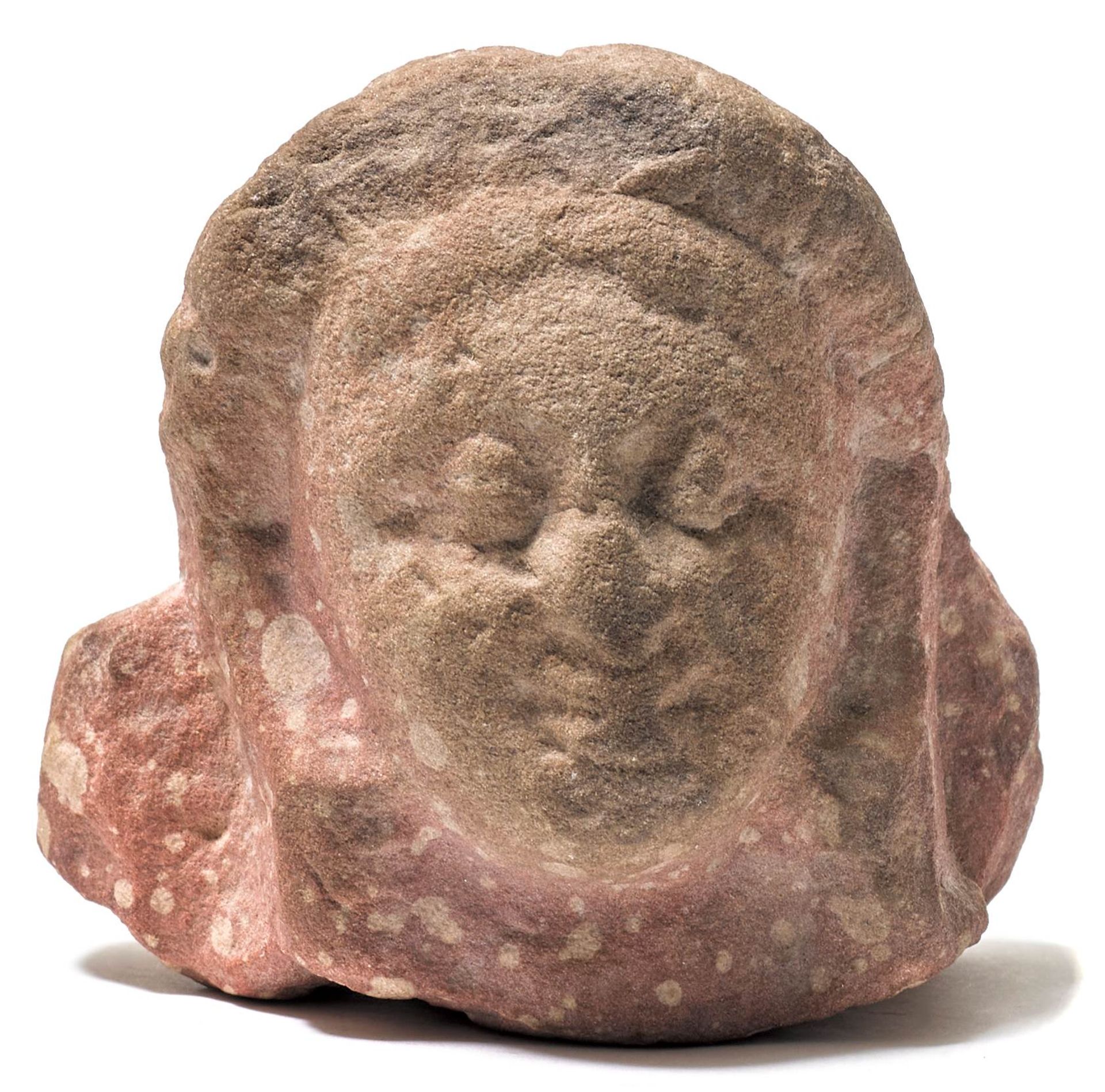 A SMALL MOTTLED RED SANDSTONE HEAD.