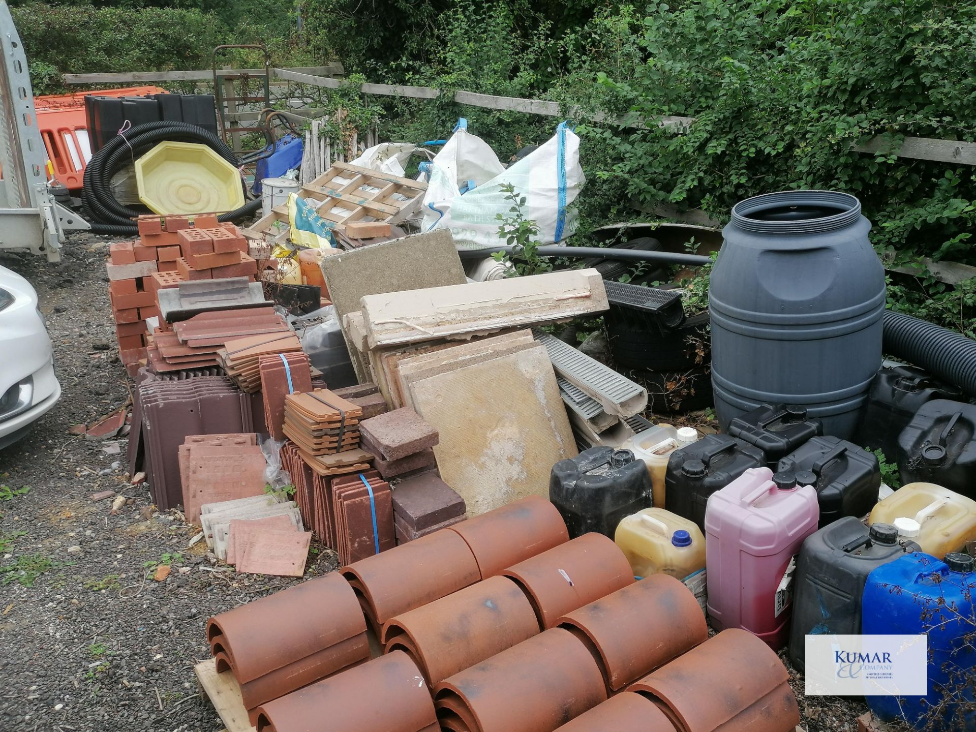 Contents of outside storage area including scafold pipes , tiles , plastic bariers , water butt as