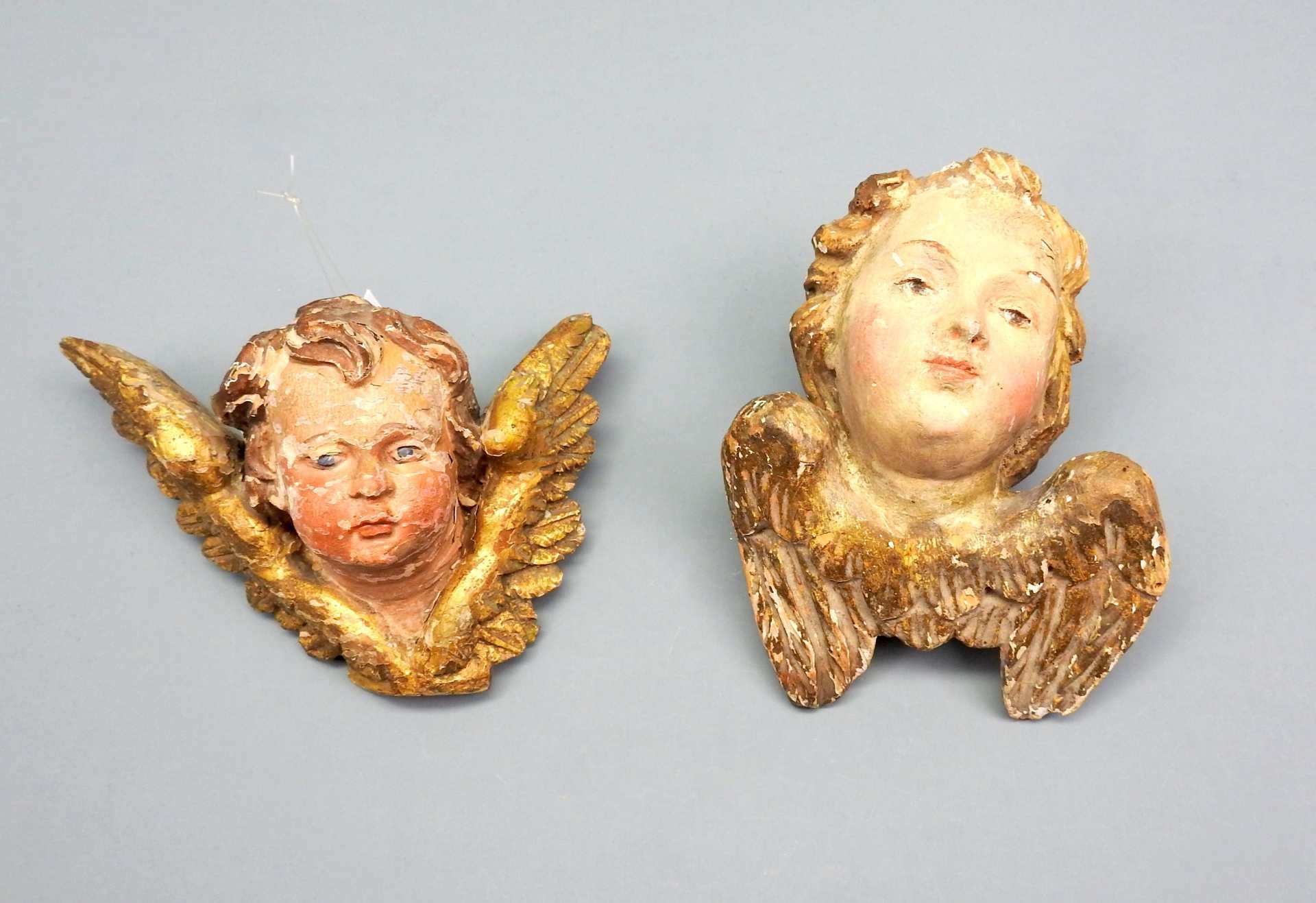 Paar Cherub-KöpfeHolz geschnitzt, polychrom gefasste Cherub-Köpfe mit goldfarbenen F