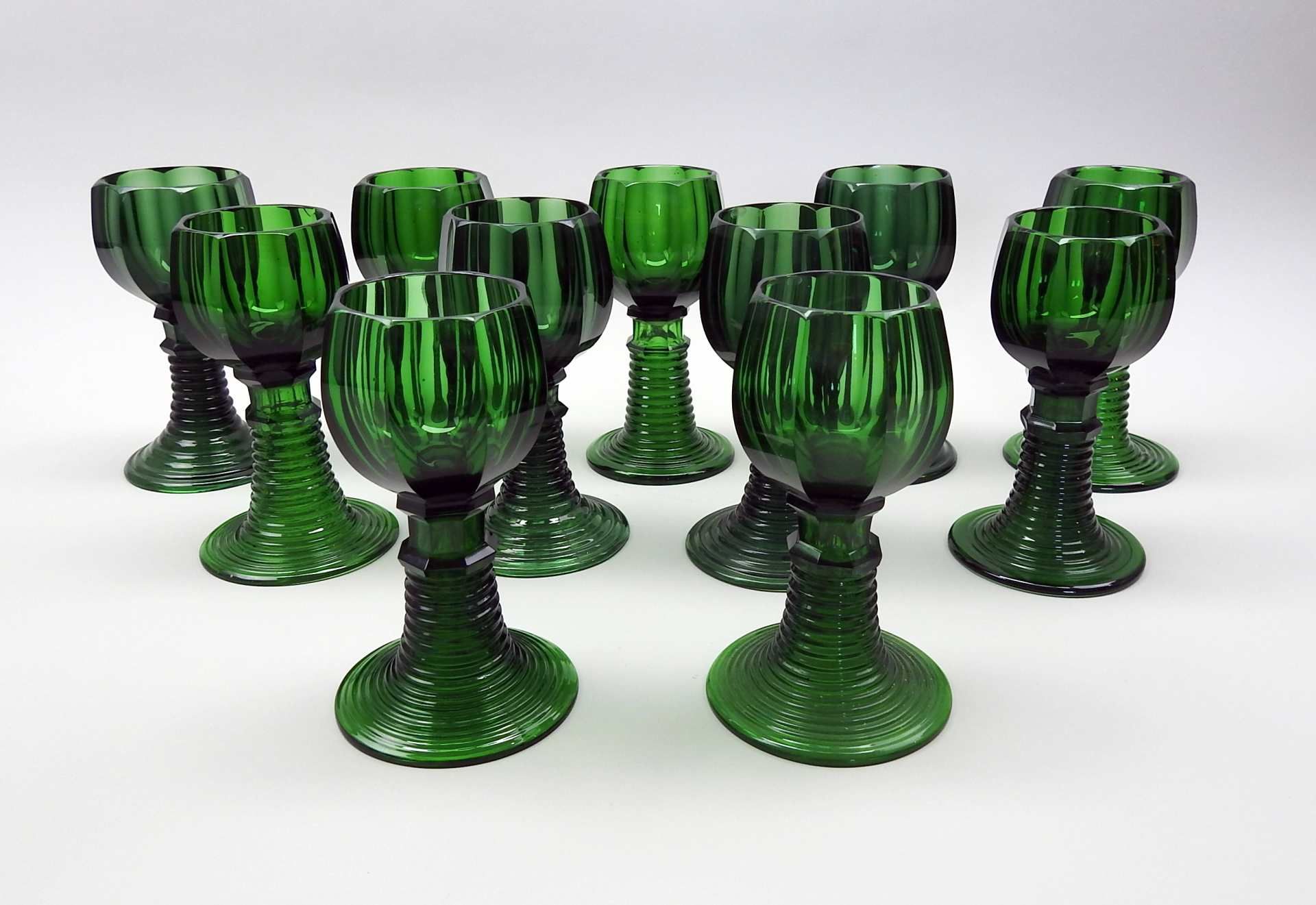 Elf WeinrömerSmaragdgrünes Glas. Nach unten offener, gerippter Fuß, bzw. Schaft auf