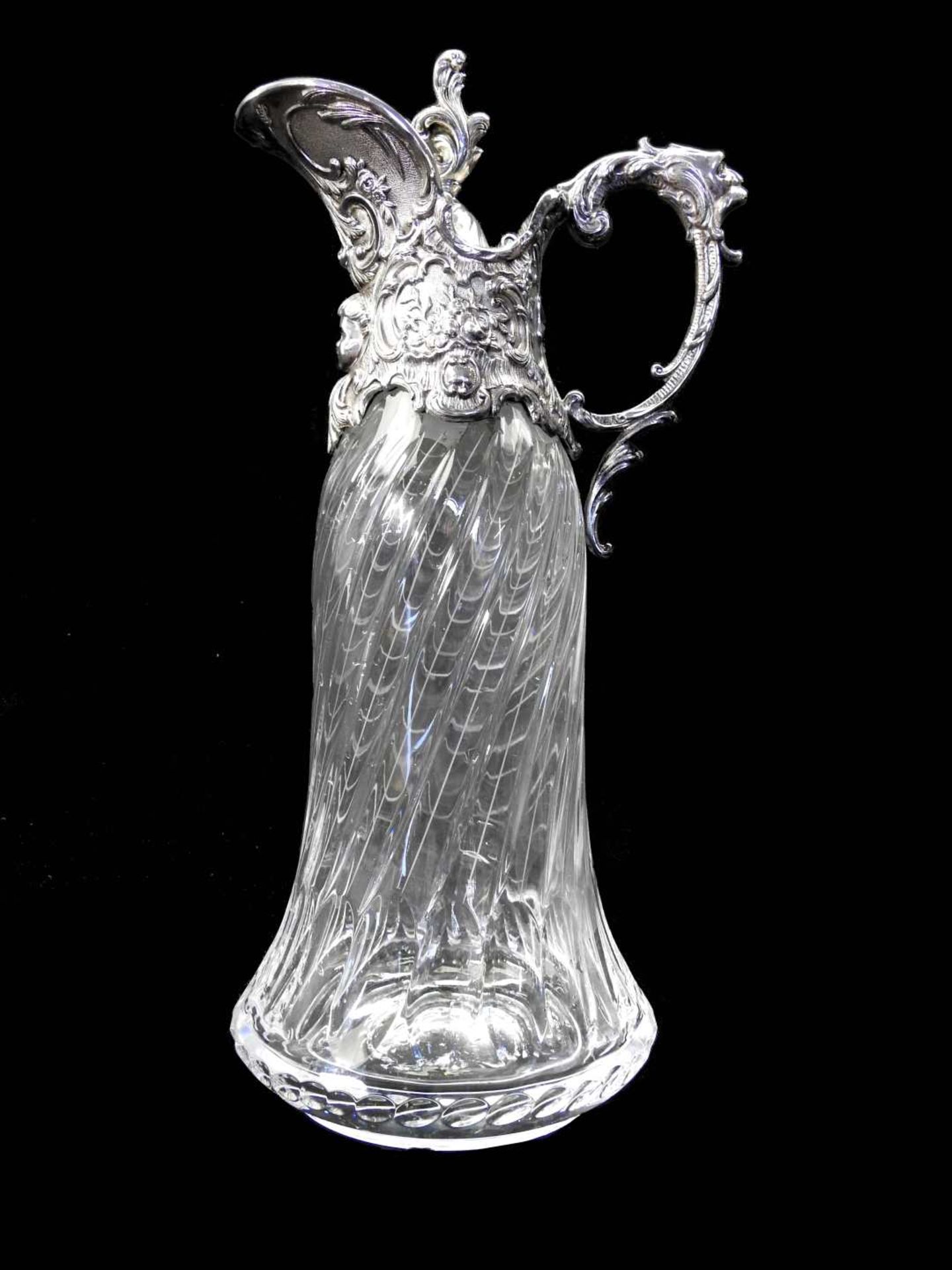 Geschwungene Glaskaraffe Glas, farblos mit leicht gedrehtem Schliffdekor. Silbermontur