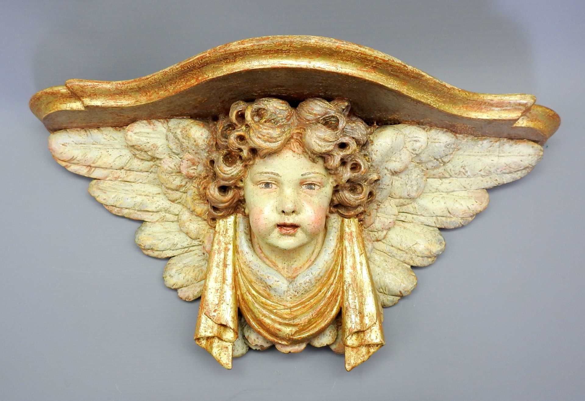 Konsole mit Engel Holz, polychrom und goldgefasst. Ein Engel mit Flügelaureole trägt