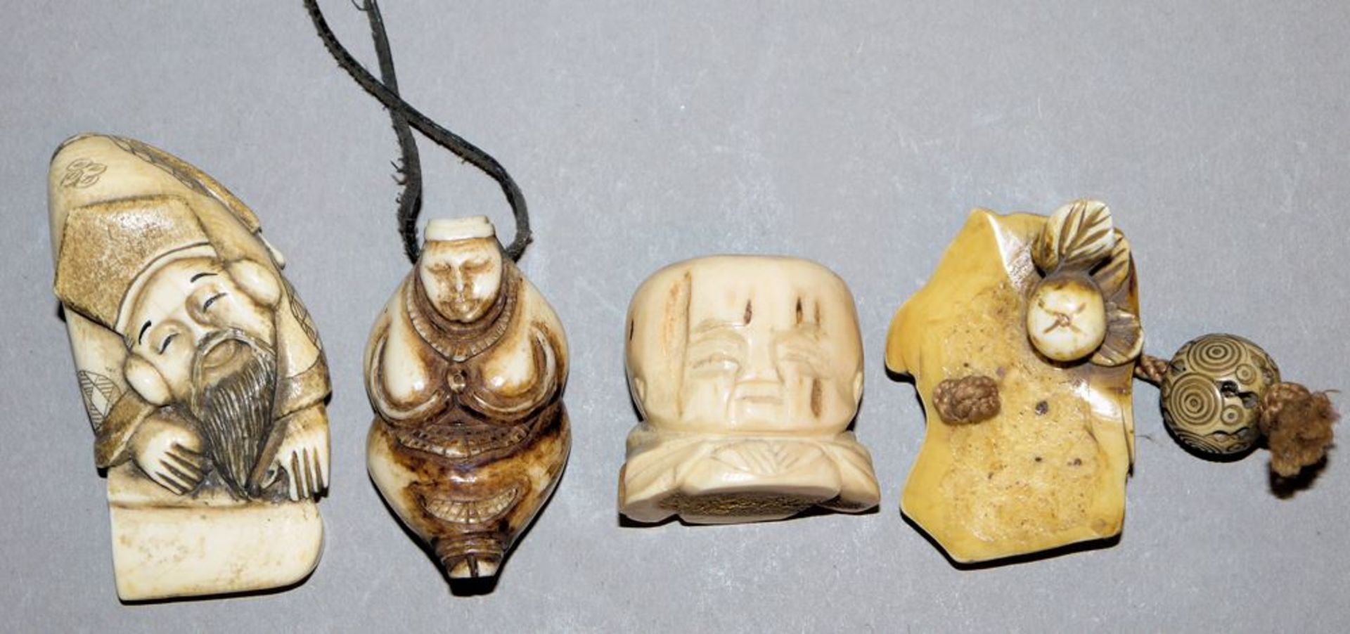 Vier Netsuke aus Walrosszahn, Elfenbein und Hirschhorn, Japan 19. & 20. Jh.