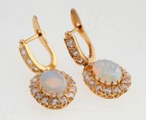 Paar Opal-Brillant-Ohrhänger585er GG. Abgehängter hochovaler Opal-Cabochon (H. 1 cm) in Bri