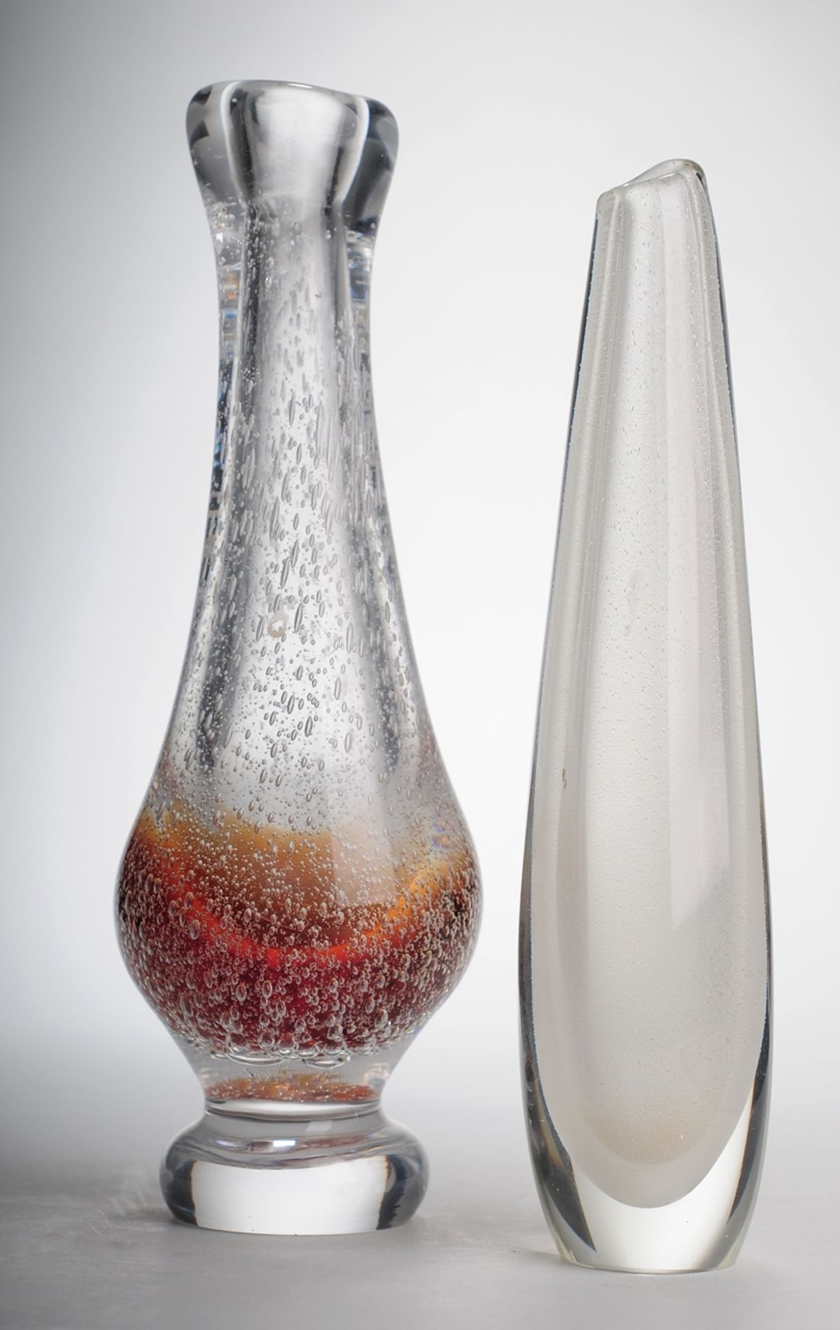 Zwei StudioglasvasenFarbloses, dickwandiges Glas, weiße bzw. rot-orange Farbpulvereinschmelz