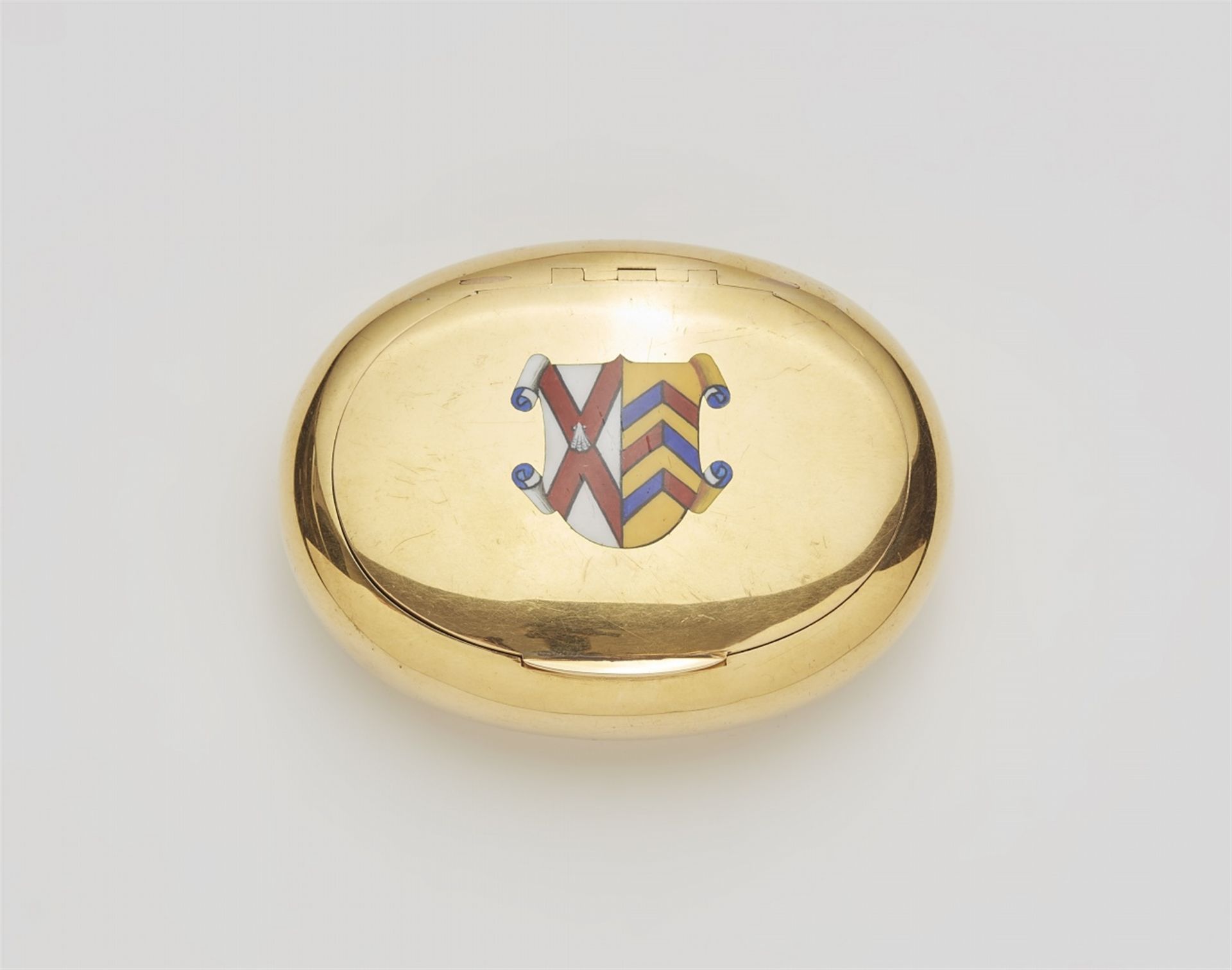 An 18k gold snuff box with an enamelled crest