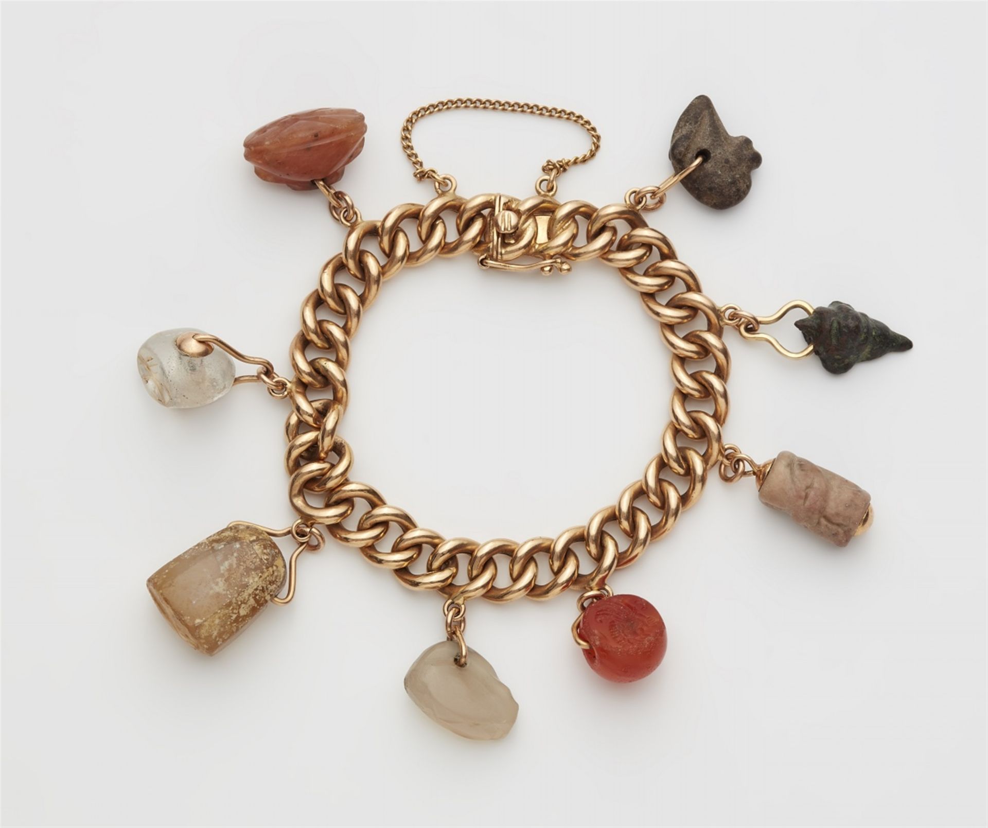 An 18k red gold charm bracelet with ancient amulets