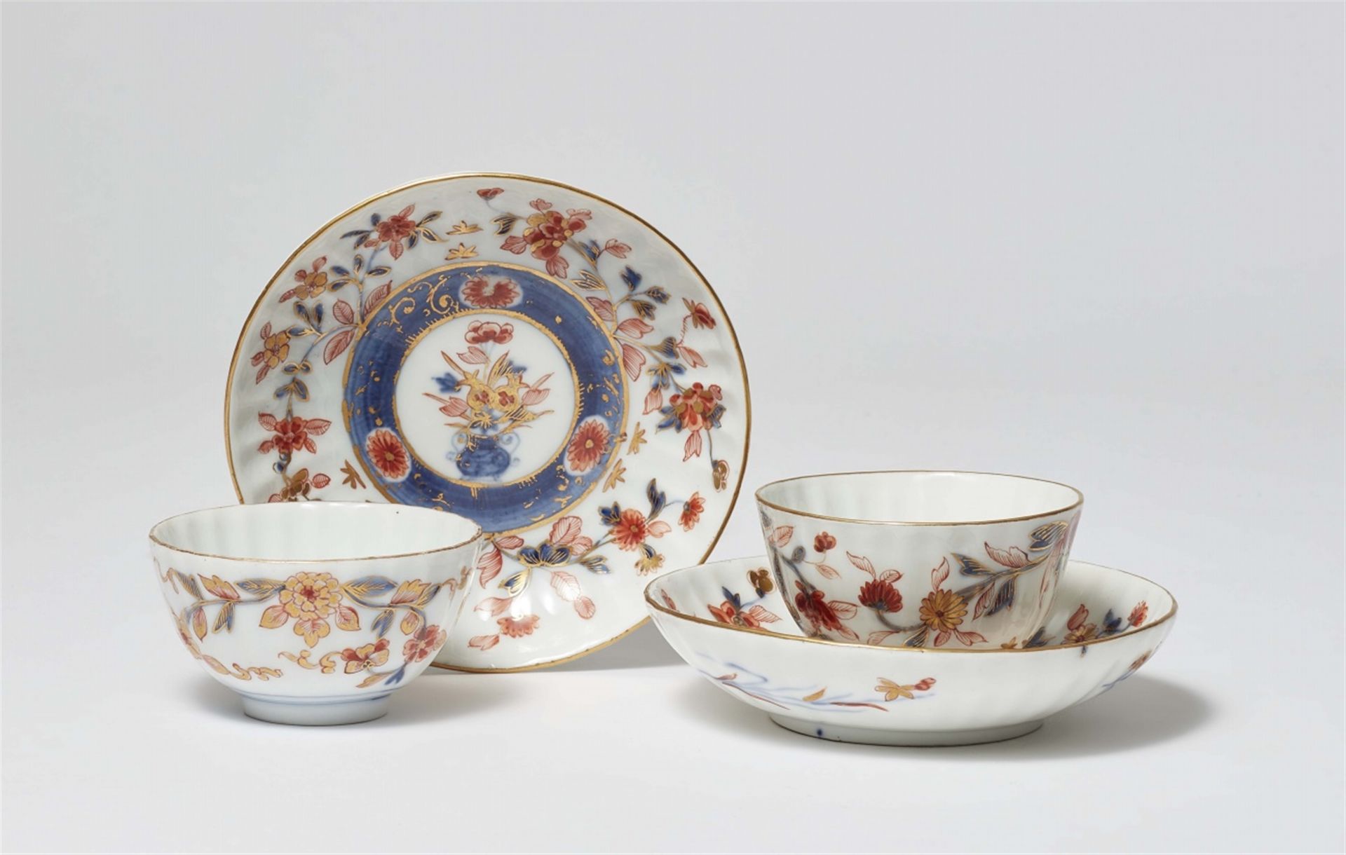 Zwei Koppchen und Untertasse mit Imari-Dekor