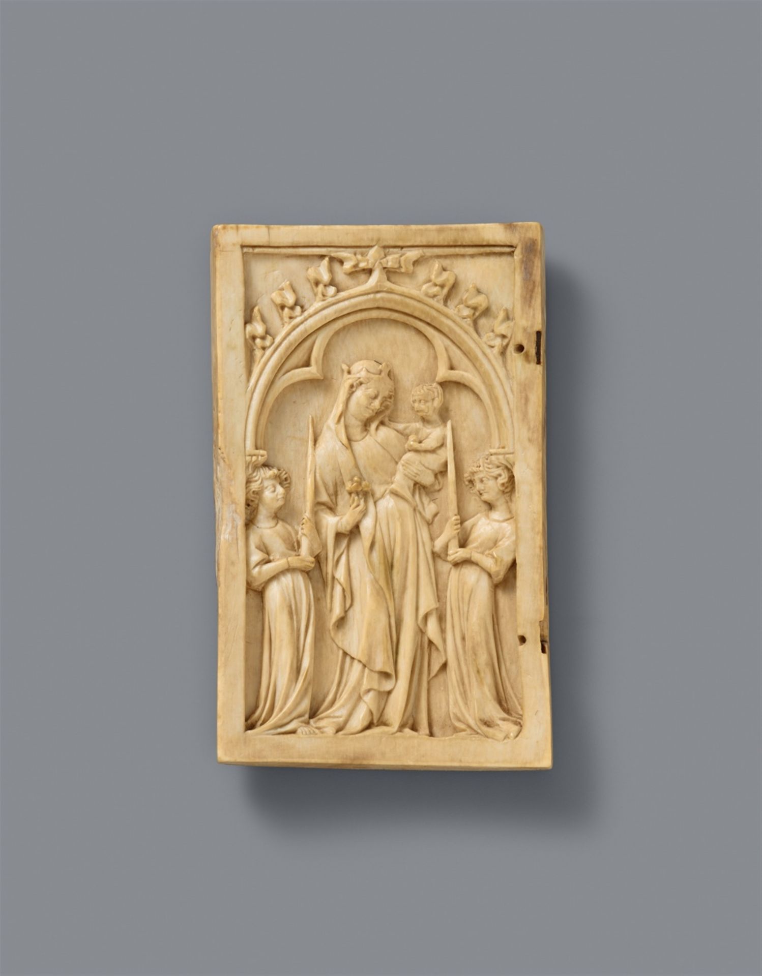 A French carved ivory relief of the Virgin and Child, first quarter 14th century
