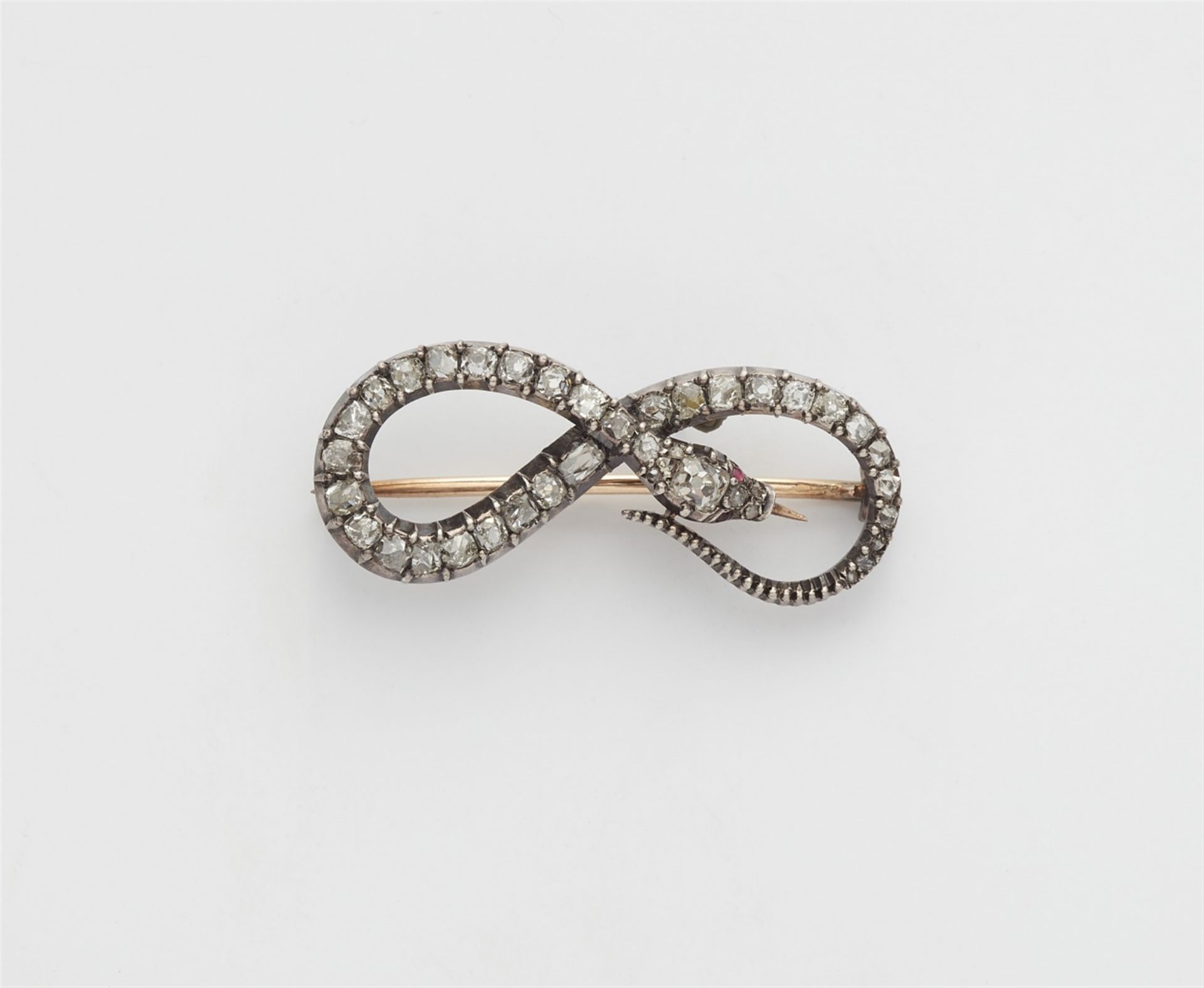 A silver and 14k gold diamond snake brooch