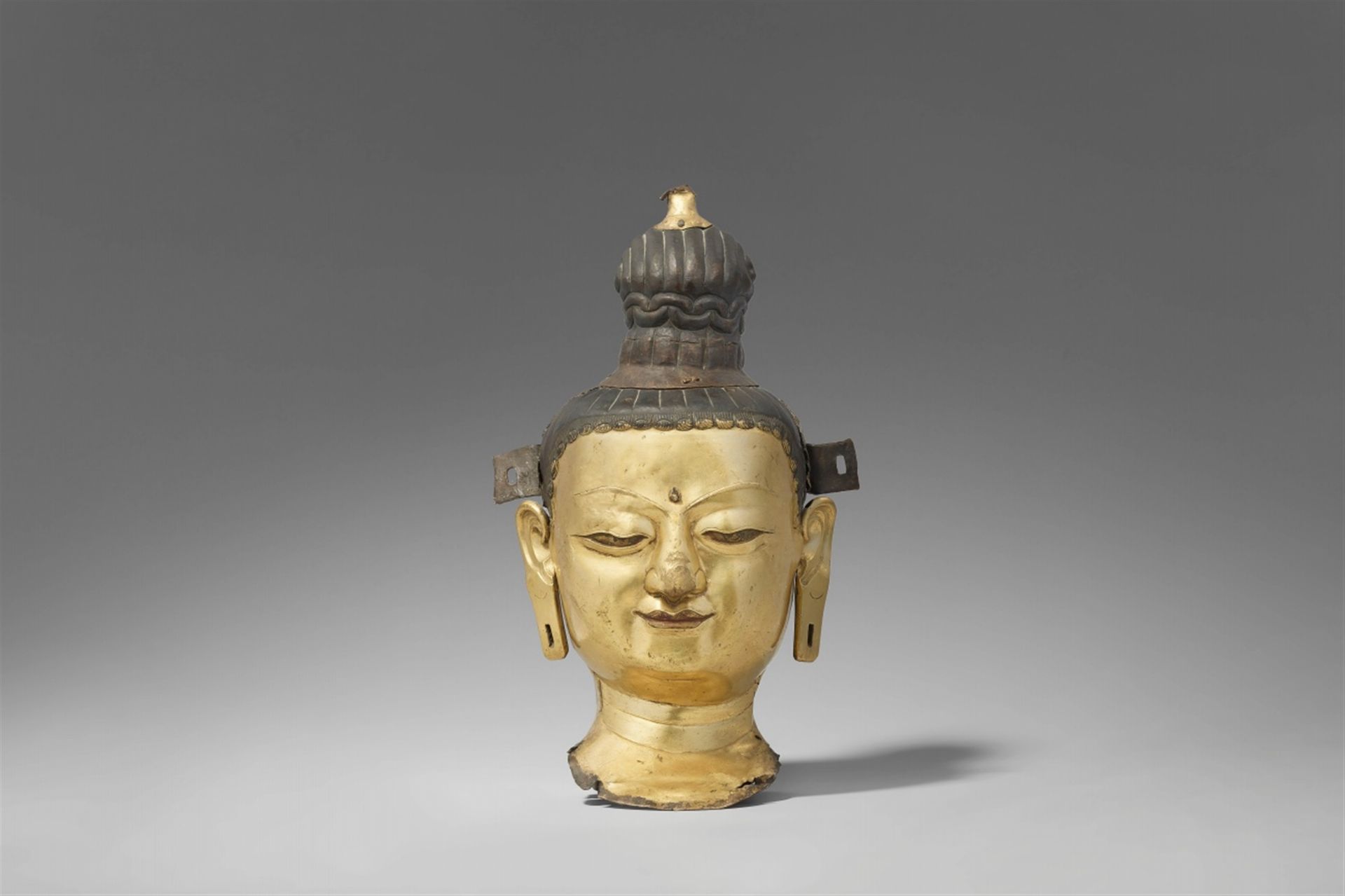 Kopf eines Bodhisattva. Kupfer-Repoussé, vergoldet. Tibet. 18./19. Jh.