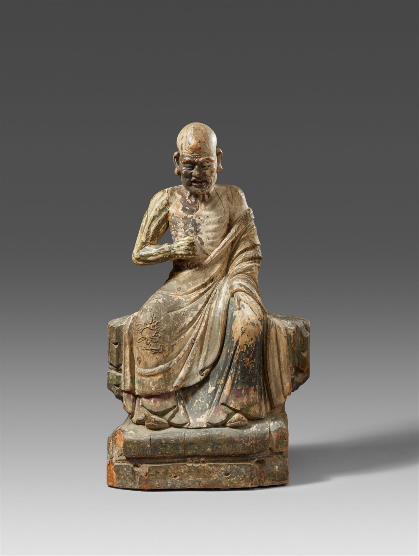 Figur eines sitzenden luohan. Holz mit Resten einer Farbfassung. Ming-Zeit, 16./17. Jh,