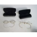 Two pairs of gold coloured metal spectacles