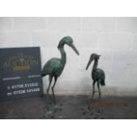 A pair of metal garden storks with bronze effect finish