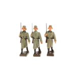 3 Lineol Soldaten im Mantel, mit Gewehr im Marsch, H 7,5, Z 2