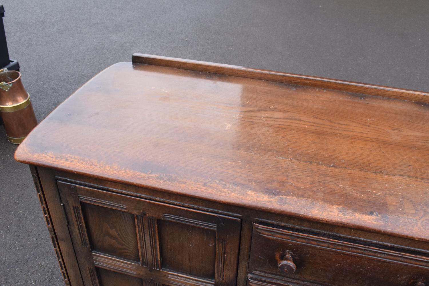 Ercol dark elm sideboard with 2 doors and 4 drawers. In good functional condition with some areas of - Image 4 of 9