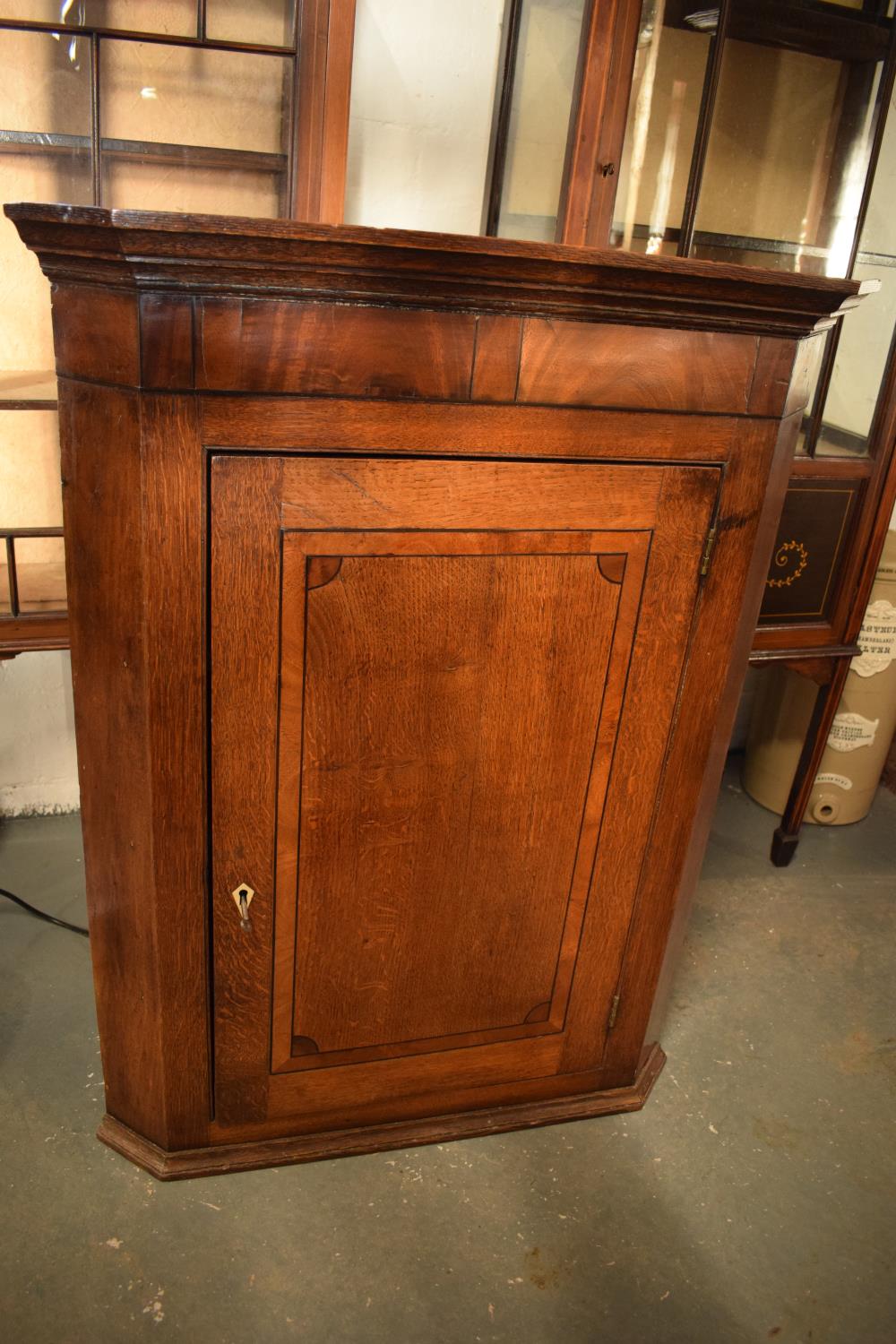 Late Georgian oak inlaid corner cabinet with a bone escutcheon. Some wear and old worm is