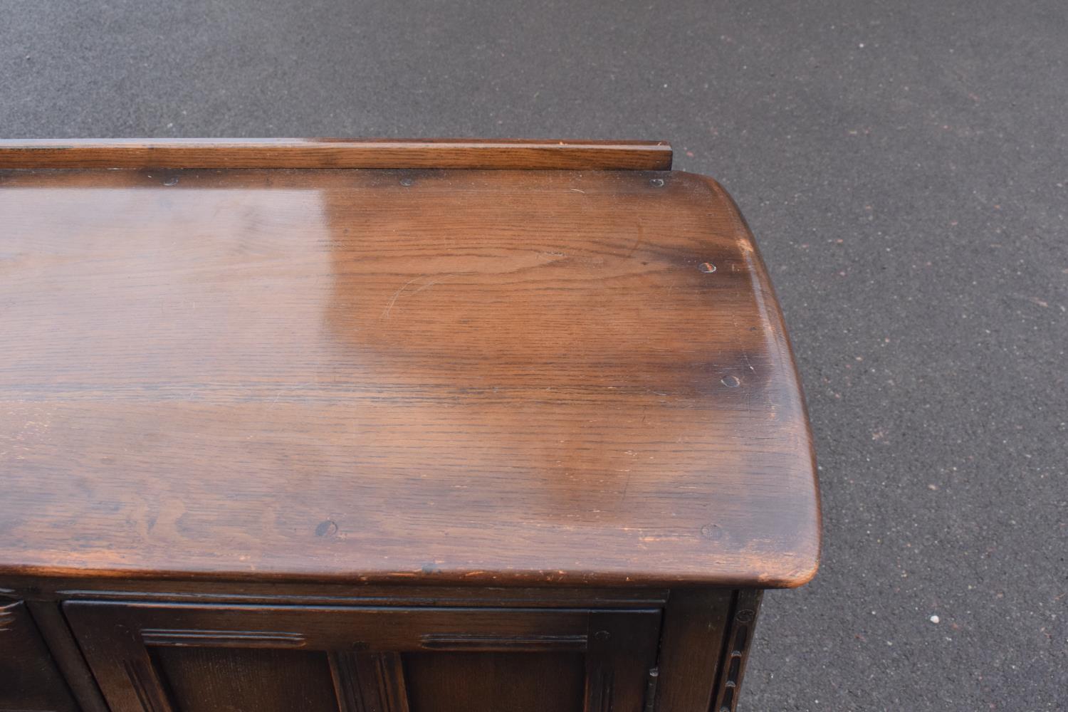 Ercol dark elm sideboard with 2 doors and 4 drawers. In good functional condition with some areas of - Image 5 of 9