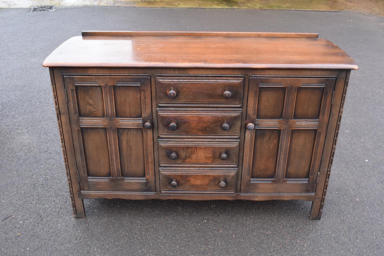 Ercol dark elm sideboard with 2 doors and 4 drawers. In good functional condition with some areas of