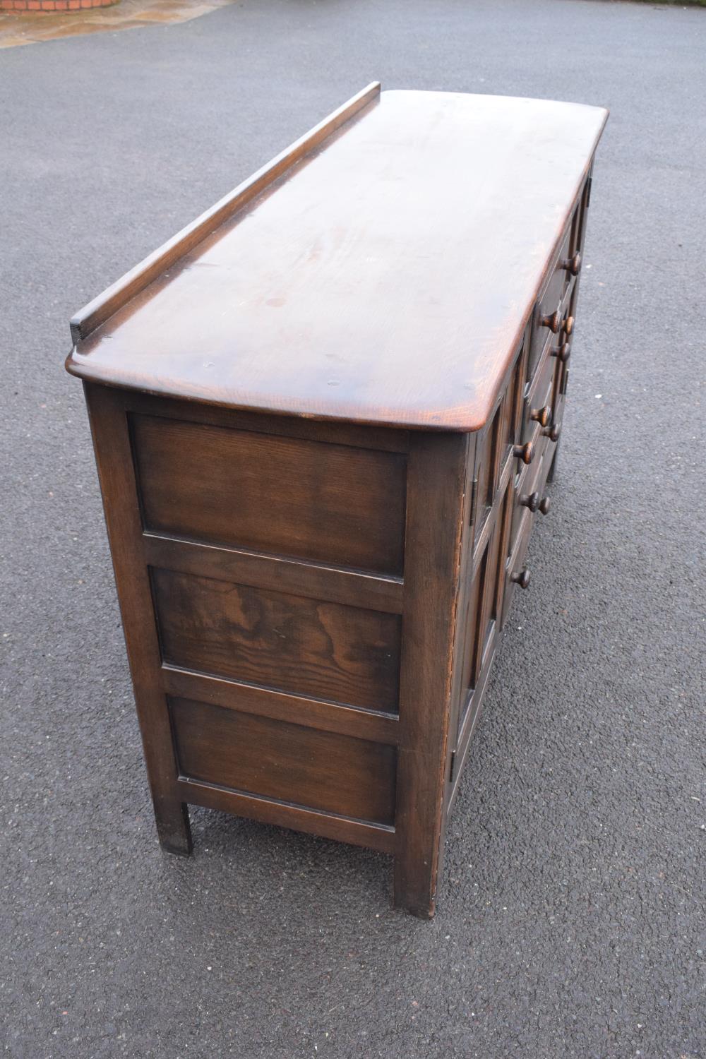 Ercol dark elm sideboard with 2 doors and 4 drawers. In good functional condition with some areas of - Image 3 of 9