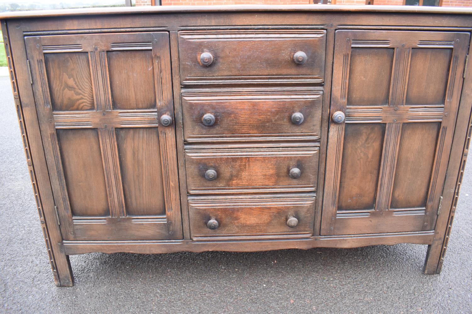 Ercol dark elm sideboard with 2 doors and 4 drawers. In good functional condition with some areas of - Image 8 of 9