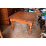 Early 20th century golden oak dining table with a spare leaf and handle. In good condition with